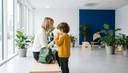 Enfant de dos se mouchant pendant qu'un parent s'agenouille près de lui en salle d'attente
