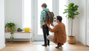 Un parent de dos ajuste la sangle du sac à dos d'un adolescent dans l'entrée d'une maison