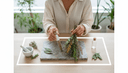 Mains comparant un tube de granules et un bouquet de plantes séchées sur une planche
