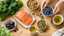 Vue de dessus d'aliments bons pour le cerveau sur une table en bois : saumon, noix, myrtilles et huile d'olive
