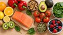 Vue de dessus d'aliments bons pour la peau sur une table en bois : saumon, agrumes, kiwi, poivrons, noix, avocat et fruits rouges