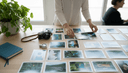 Mains alignant des photographies imprimées sur une table près d'un appareil argentique