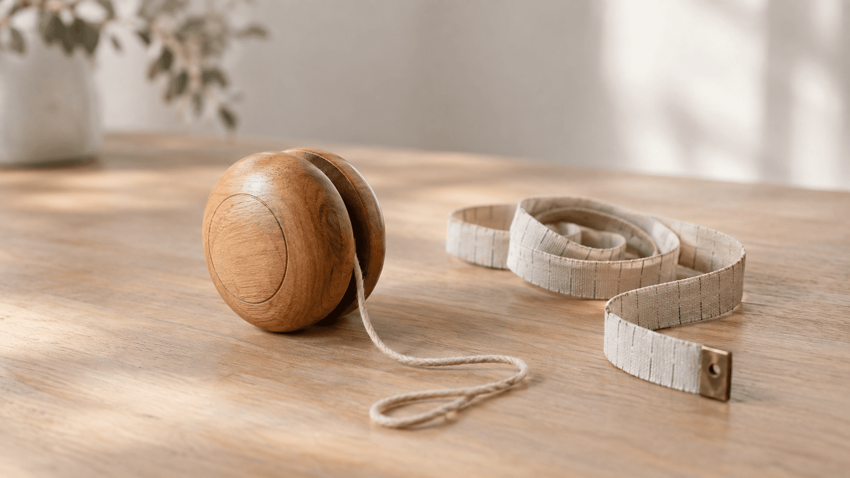 Yo-yo en bois et mètre ruban souple posés sur une table, image éditoriale neutre évoquant l'effet yo-yo des régimes