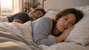 Couple au lit à l'aube, l'un dort paisiblement tandis que l'autre reste éveillé et fatigué par le ronflement nocturne